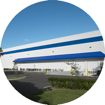 The hand of a person holding a scanner and pointing it at the barcode on the end of an archive box on a shelf